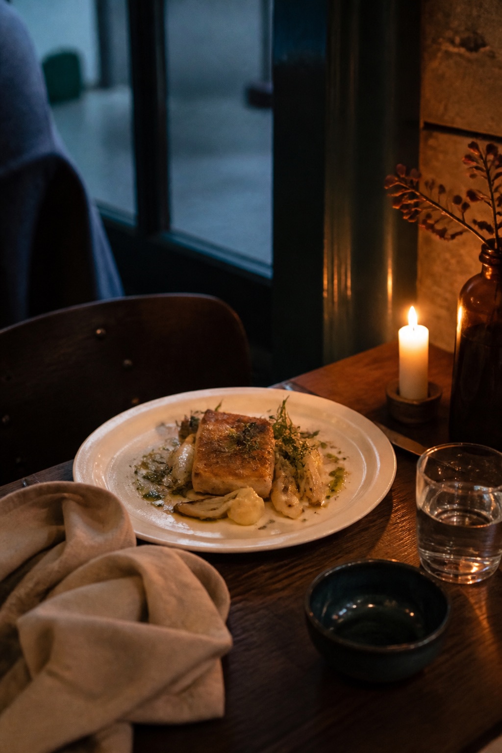 Dukat restaurangbord i kvällsljus, tallrik och glas